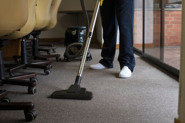 A special event cleaning services vacuums a carpet.